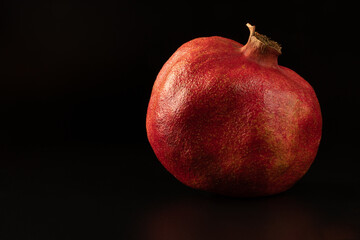 Isolated Red Pomegranate Close-up on Black Background. Healthy vegetables concept.