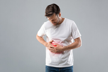 Man holding his right side, suffering from liver pain