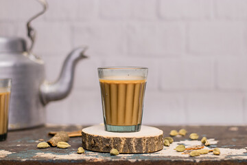 Indian chai in glass cups with metal kettle and other masalas to make the tea.  - obrazy, fototapety, plakaty