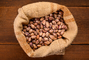 Colored beans on wooden background.