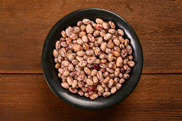 Colored beans on wooden background.