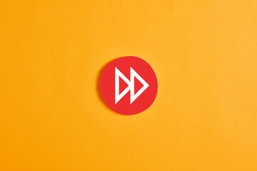Red round circle with a fast forward button or icon