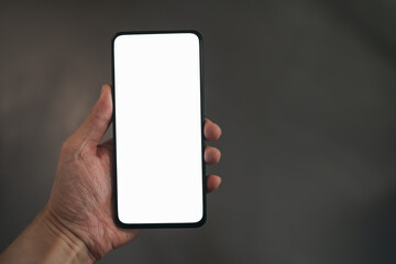 Man hold smartphone with white screen in his hand standing indoors in home environment