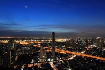 Cityscape of Bangkok after sunset in blue hour with skyscraper and city view with crossroad 