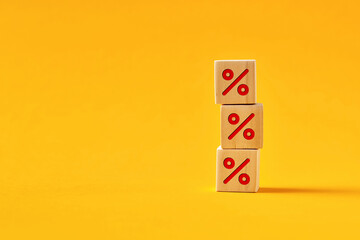 Percent sign on wooden cubes on yellow background. Business and finance discount or rate
