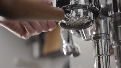 low angle flush coffee machine before extraction with naked portafilter into white cup