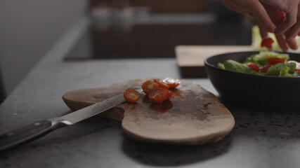 man hand take cherry tomatoes into bowl to make salad on home kitchen