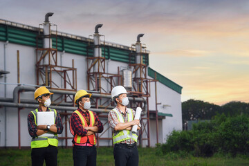 engineer discusses technical documentation with his help in the territory of a modern plant.Engineers working in the power plant area