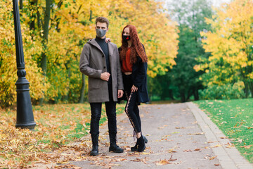 Young couple wearing masks together in forest