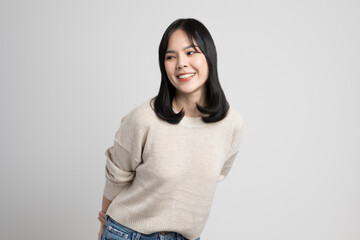 Beautiful young asian woman smiling and happy. Charming female standing on isolated white background.