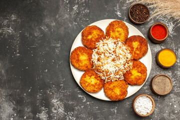 top view fried cutlets with cooked rice and seasonings on dark floor food dish photo meat
