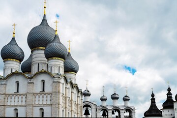 Russia, Rostov, July 2020. Bells and domes of churches against the background of the cloudy sky.
