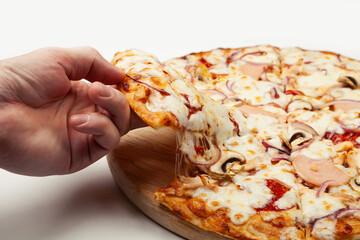 Man's hand takes a delicious slice of pizza with Margarita or Margarita with Mozzarella cheese, A man takes a slice of Italian pizza and pulls out an appetizing melted cheese