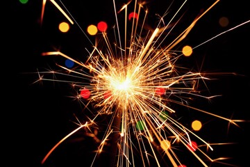 Obraz premium Sparkler with beautiful abstract colorful background. Concept for Christmas and Happy New Year 2021.