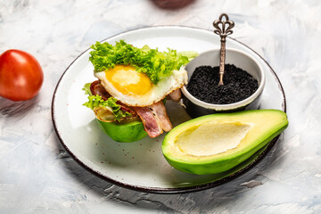 Ketogenic diet breakfast. avocado burger with bacon, egg, tomato, Keto, paleo lunch, Restaurant menu, dieting, cookbook recipe, place for text