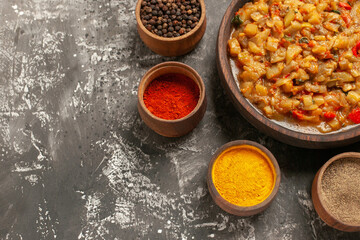 top view roasted eggplant salad in bowl different spices in bowls on dark background copy space