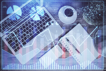 Financial market graph and top view computer on the desktop background. Double exposure. Investment concept.