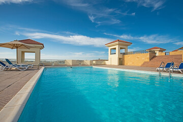 Fototapeta na wymiar Rooftop swimming pool in a luxury tropical hotel resort