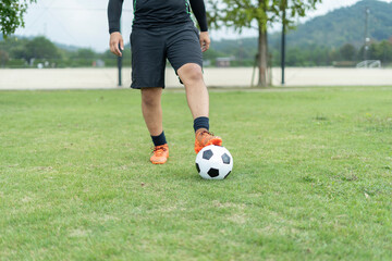 Obraz premium 公園でサッカーをする若い男性
