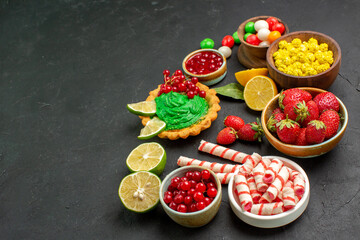 front view yummy cake with fruits and candies on dark background cookie biscuit sweet