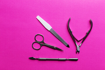 Set of manicure and pedicure tools with space.A classic metal kit of nail scissors and manicure tools on a pink background.Nail care objects.