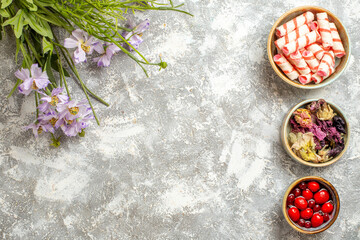 top view sweet confitures with jelly and flowers on whtie background candy sugar sweet