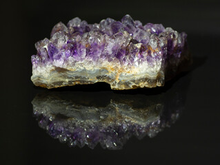 Natural amethyst druse isolated on  black background . Amethyst crystal close up. Reflection. Macro.