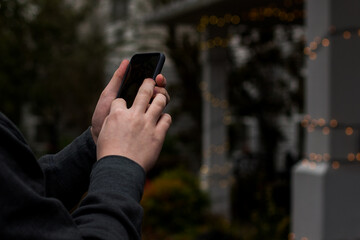 Man's  hands close-up using cell phone outdoors in urban area