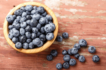 Fresh blueberries in a wooden bowl. Healthy and dietary food concept.