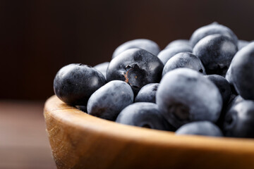 Fresh blueberries in a wooden bowl. Healthy and dietary food concept.