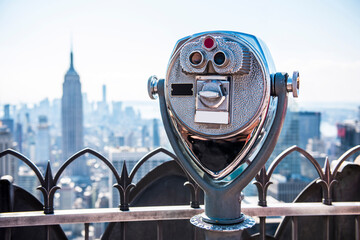 Tourist binoculars at top of building with Manhattan skyline view. New York.