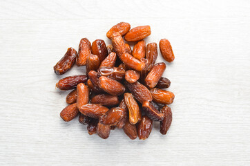 Dried sweet dates on white wooden background.