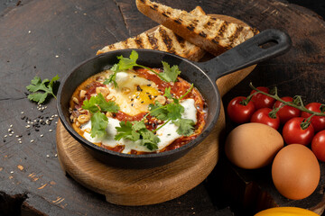 Chef’s style shakshuka. A classic Israeli dish of eggs fried in a sauce of tomatoes, hot peppers, onions and spices. Kasher hot dish of Jewish cuisine.