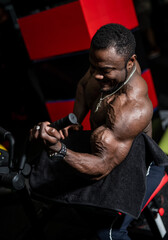 Fototapeta na wymiar Fit young black man lifting barbells doing workout at a gym. Sport, fitness, weightlifting, bodybuilding, training, athlete, workout exercises concept. View from the side.