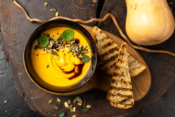 Pumpkin cream soup with grilled white bread. Pumpkin seed, balsamic, fried quinoa. Diet vegan hot boiled vegetable dish.