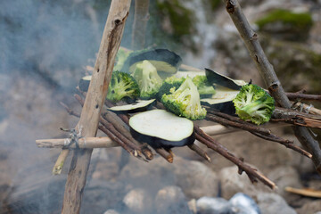Cooking vegetables in the open air. Camping in the nature. Smoked vegetables.