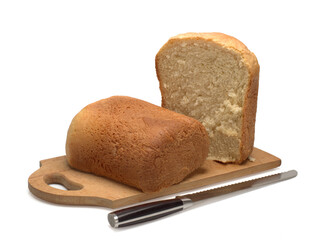 fresh white bread on a wooden board and a knife