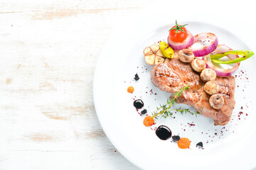 Grilled pork steak with sauce on a plate. Top view. Free copy space.