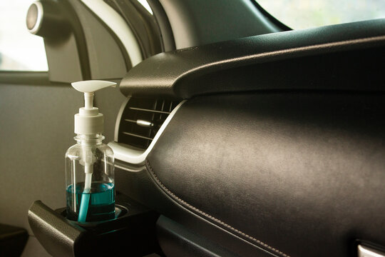 Pump Bottle Of Hand Sanitizer Placed In A Car’s Cup Holder. Kill Germs, Viruses And Bacteria While Traveling. Stop Covid-19