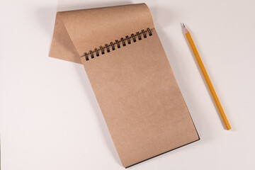 brown notepad spiral pencil on white background