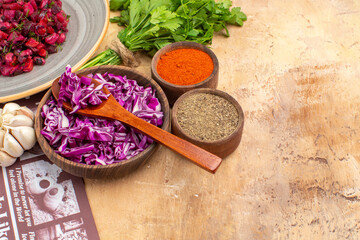 Obraz na płótnie Canvas top view prepare a bowl of chopped red cabbage togther with a bunch of parsley garlic a bowl of black pepper turmeric ground pepper for beet salad on a wooden table with copy place