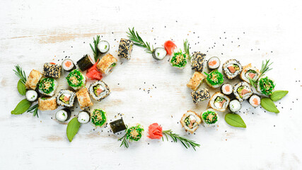 Set of tasty sushi and maki rolls on white wooden background. Japanese food. Top view. Free space for your text. © Yaruniv-Studio
