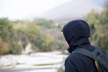 The man looks at the landscape from the bridge