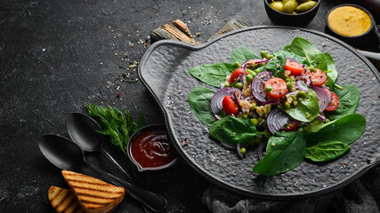 Healthy vegan salad of spinach, quinoa, tomatoes and vegetables. Top view. Rustic style.