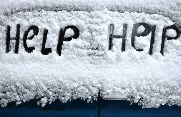 Handwritten Help on a snowy car window.