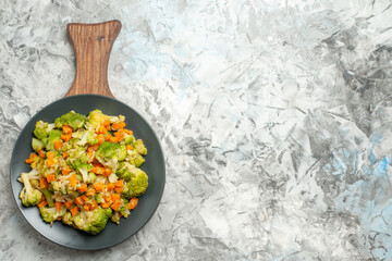 Fresh and healthy vegetable salad on wooden cutting board on the left side of the white background