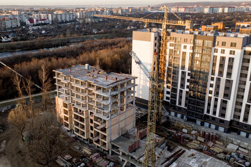 Fototapeta premium Construction and construction of high-rise buildings, the construction industry with working equipment and workers. View from above, from above. Background and texture