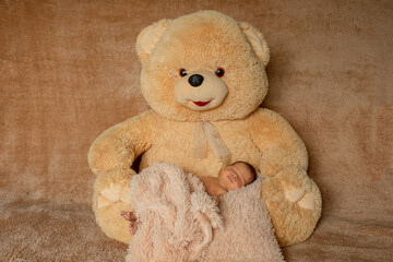 Two week old newborn baby sleeping on teddy bear