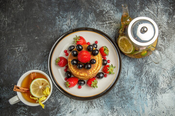 top view yummy pancakes with fruits and tea on light background sweet fruit breakfast