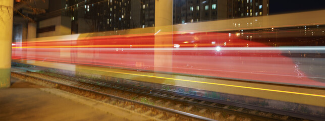 Fototapeta na wymiar Long exposure photography. Defocused photography of Moscow cityscape in night time. Blurred motion of cable car. Golden and red lights of tram